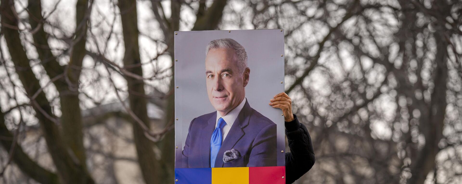 A man holds a portrait of Calin Georgescu, the winner of Romania's first round of presidential election, annulled by the Constitutional Court. File photo - Sputnik International, 1920, 11.03.2025