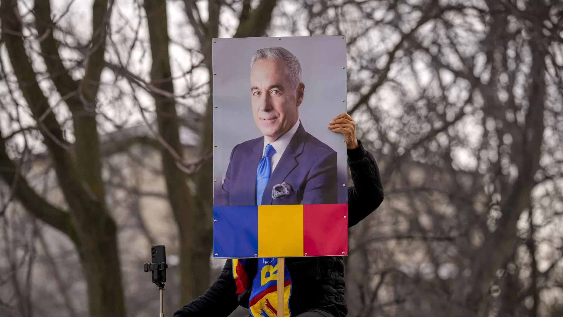 A man holds a portrait of Calin Georgescu, the winner of Romania's first round of presidential election, annulled by the Constitutional Court. File photo - Sputnik International, 1920, 11.03.2025