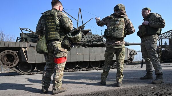 Russian servicemen are seen near Ukraine's destroyed M1 Abrams tank. File photo - Sputnik International