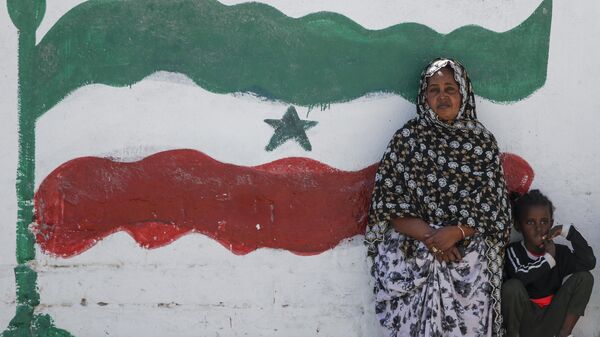 FILE - A woman and child relax next to a mural of Somaliland's flag, in Hargeisa, Somaliland, a semi-autonomous breakaway region of Somalia - Sputnik International