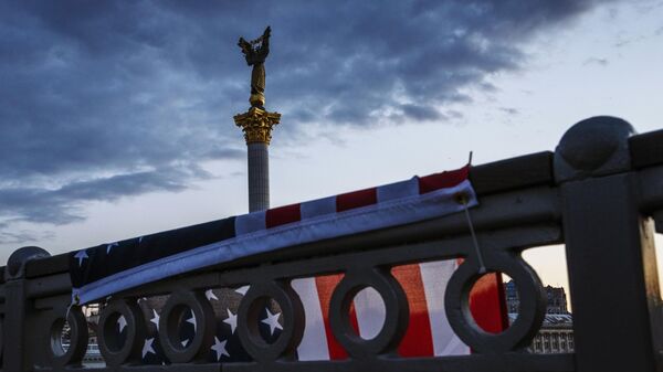 A US flag hangs over a bridge overlooking The Independence Monument, in Kiev's Maidan Square, Ukraine, June 25, 2022. - Sputnik International