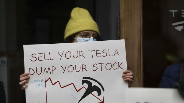  A person protesting Elon Musk's actions in the Trump administration holds a sign outside a Tesla showroom in Seattle on Thursday, Feb. 13, 2025.  - Sputnik International
