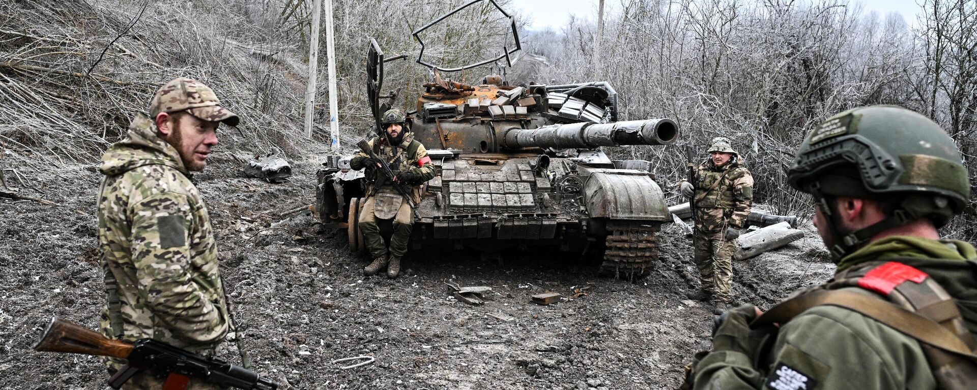 Russian servicemen seen next to a destroyed Ukrainian T-64 tank amid Russia's military operation in Ukraine, in the village of Russkoye Porechnoye, Kursk region, Russia. - Sputnik International, 1920, 11.05.2025