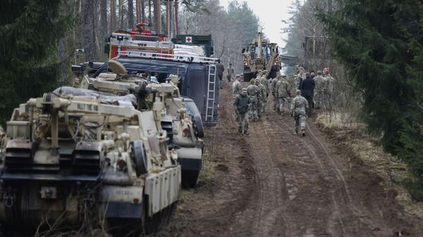 US Army soldiers walk during recovery efforts for four missing US soldiers near the spot where their Hercules armored vehicle was found submerged at a training range in Pabrade, north of the capital Vilnius, Lithuania on Friday, March 28, 2025. - Sputnik International