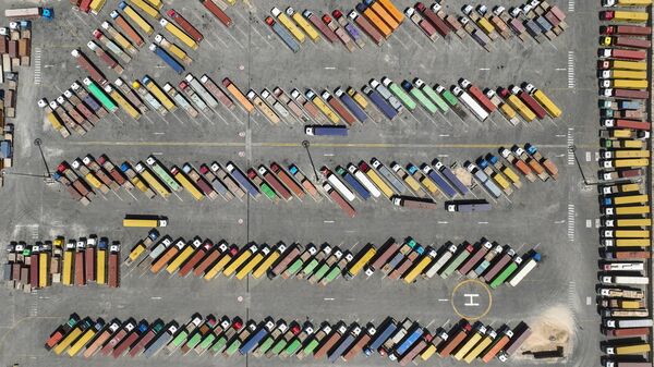 In this aerial view, trucks and containers are parked at Iraq's main port of Umm Qasr, near the city of Basra, 340 miles (550 kilometers) southeast of Baghdad, Iraq, Wednesday, April 9, 2025. - Sputnik International