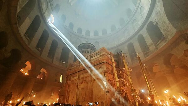 Believers with candles and lamps lit by the Holy Fire in the Cathedral of the Holy Sepulchre in Jerusalem.  - Sputnik International