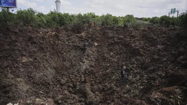 Israeli security forces inspect a crater at the site where the Israeli military said a projectile fired by Yemen's Houthi rebels landed in the area of Ben Gurion International Airport near Tel Aviv, Israel, on Sunday, May 4, 2025.  - Sputnik International