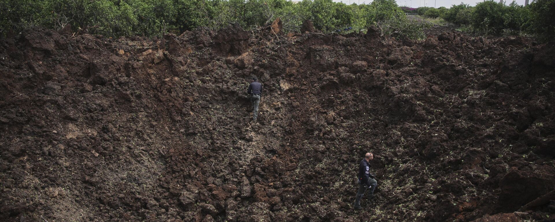 Israeli security forces inspect a crater at the site where the Israeli military said a projectile fired by Yemen's Houthi rebels landed in the area of Ben Gurion International Airport near Tel Aviv, Israel, on Sunday, May 4, 2025.  - Sputnik International, 1920, 04.05.2025