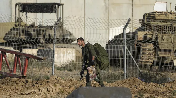 Israeli troops are seen near the border with Gaza Strip in southern Israel, Sunday, Jan. 19, 2025. - Sputnik International