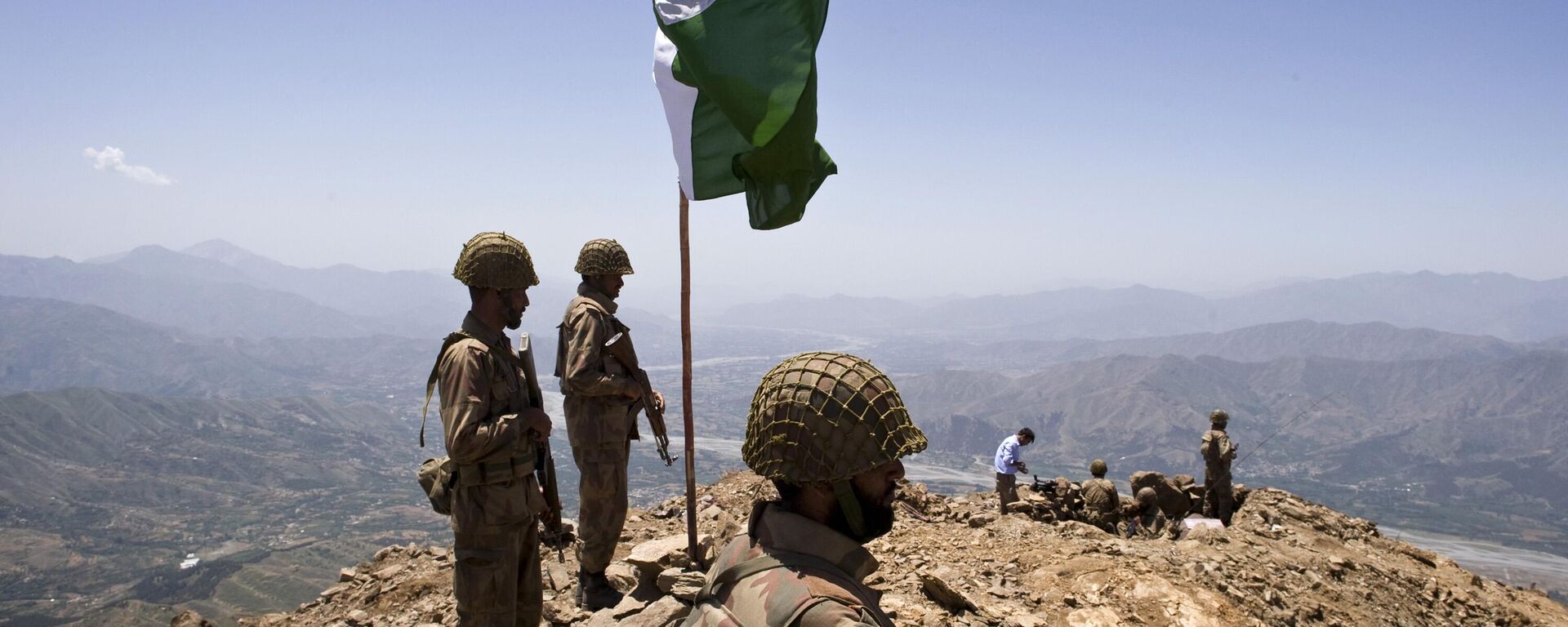 A Pakistani flag flies over government troops installed on top of a defense position on a former base of Taliban militants overlooking the Swat Valley, at Banai Baba Ziarat area, northwest of Pakistan's capital Islamabad, Pakistan, Friday, May 22, 2009 - Sputnik International, 1920, 10.05.2025