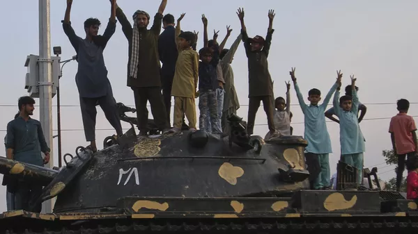 Pakistanis flash victory signs as they celebrate on top of a model of a tank following India and Pakistan have reached a ceasefire deal, during a demonstration, in Multan, Pakistan, Saturday, May 10, 2025.  - Sputnik International