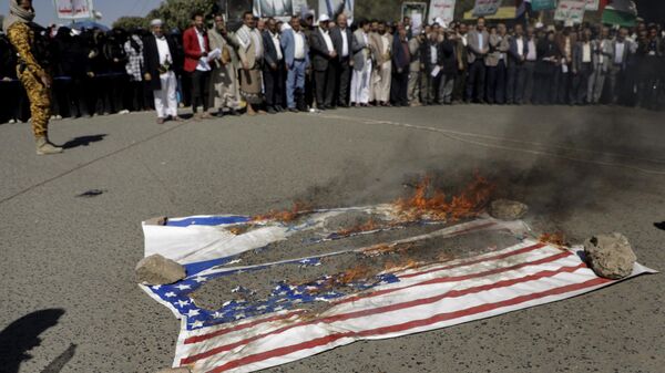 Houthi supporters burn American and Israeli flags during a protest in Sanaa, Yemen, Wednesday, Jan. 22, 2025.  - Sputnik International