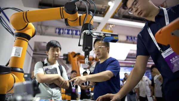 FILE - In this Aug. 18, 2018, file photo, visitors look at a manufacturing robot from Chinese robot maker Aubo Robotics at the World Robot Conference in Beijing, China. - Sputnik International