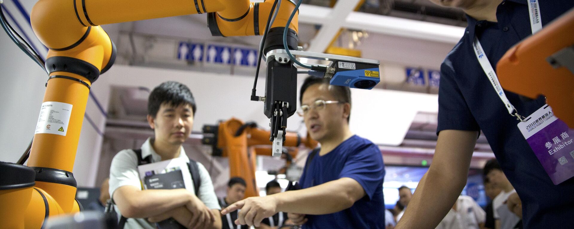 FILE - In this Aug. 18, 2018, file photo, visitors look at a manufacturing robot from Chinese robot maker Aubo Robotics at the World Robot Conference in Beijing, China. - Sputnik International, 1920, 25.05.2025