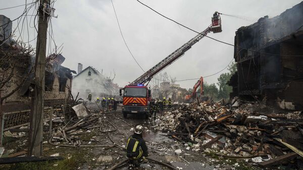 Rescue workers extinguish a fire of a building destroyed by a strike in a village in Kiev region, Sunday, May 25, 2025. - Sputnik International