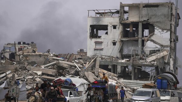 Displaced Palestinians fleeing Beit Lahia amid ongoing Israeli military operations in the Gaza Strip arrive in Jabalia, northern Gaza, on Sunday, May 18, 2025.  - Sputnik International