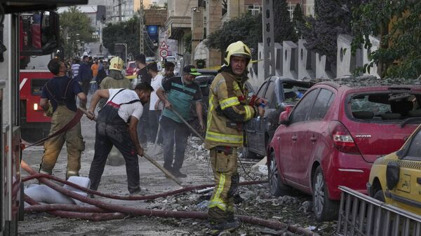 Firefighters and people clean up the scene of an explosion at a residence compound after Israeli attacks in Tehran, Friday, June 13, 2025.  - Sputnik International