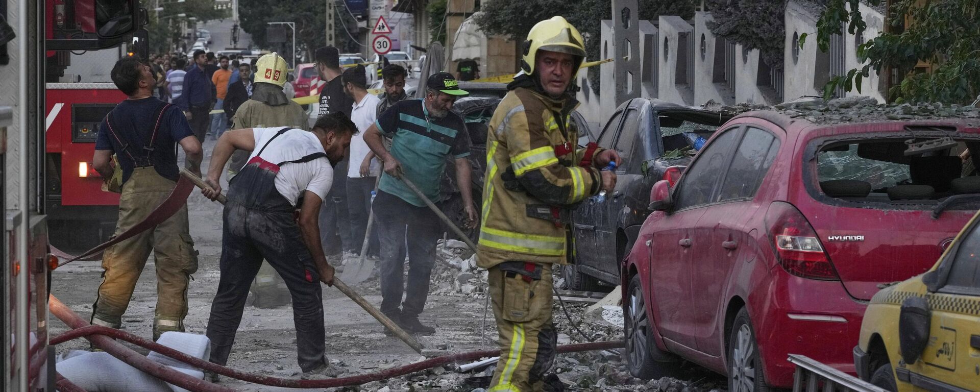 Firefighters and people clean up the scene of an explosion at a residence compound after Israeli attacks in Tehran, Friday, June 13, 2025.  - Sputnik International, 1920, 25.06.2025