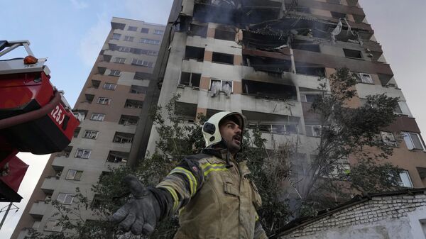 A firefighter calls out his colleagues at the scene of an explosion in a residence compound in northern Tehran, Iran, Friday, June 13, 2025.  - Sputnik International
