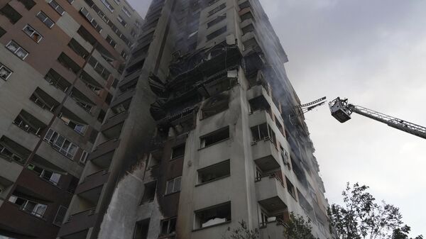 A firefighter stands on a crane at the scene of an explosion at a residence compound after Israeli attacks in Tehran, Friday, June 13, 2025. - Sputnik International