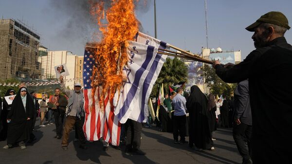 Iranian demonstrators burn representations of the Israeli and US flags in an anti-Israeli gathering at Felestin (Palestine) Sq. in Tehran, Iran, Tuesday, Oct. 8, 2024.  - Sputnik International