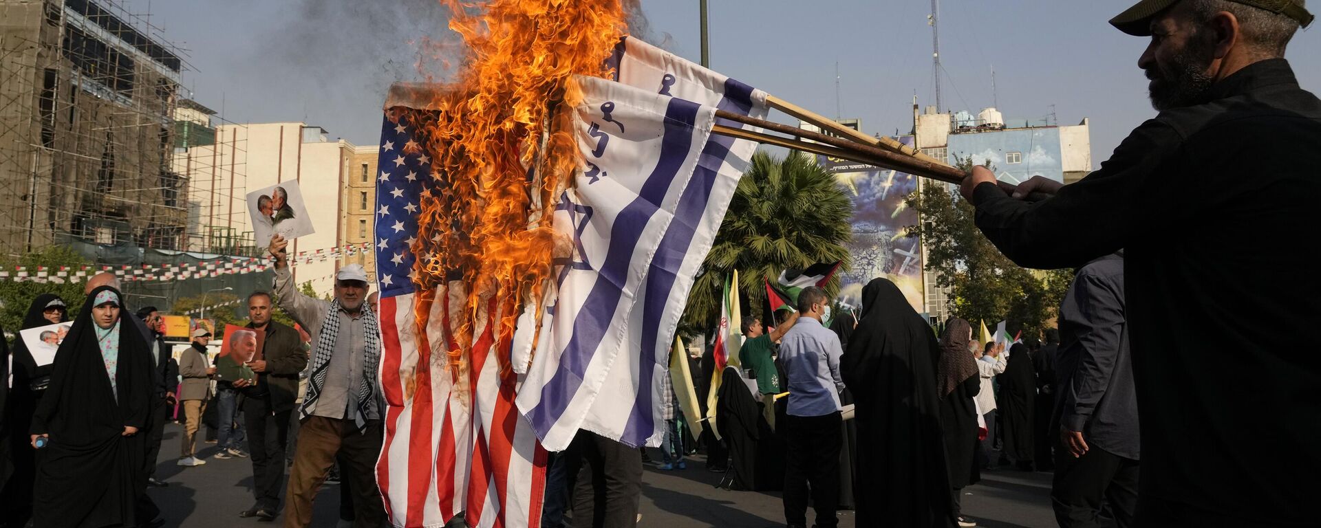 Iranian demonstrators burn representations of the Israeli and US flags in an anti-Israeli gathering at Felestin (Palestine) Sq. in Tehran, Iran, Tuesday, Oct. 8, 2024.  - Sputnik International, 1920, 16.02.2026