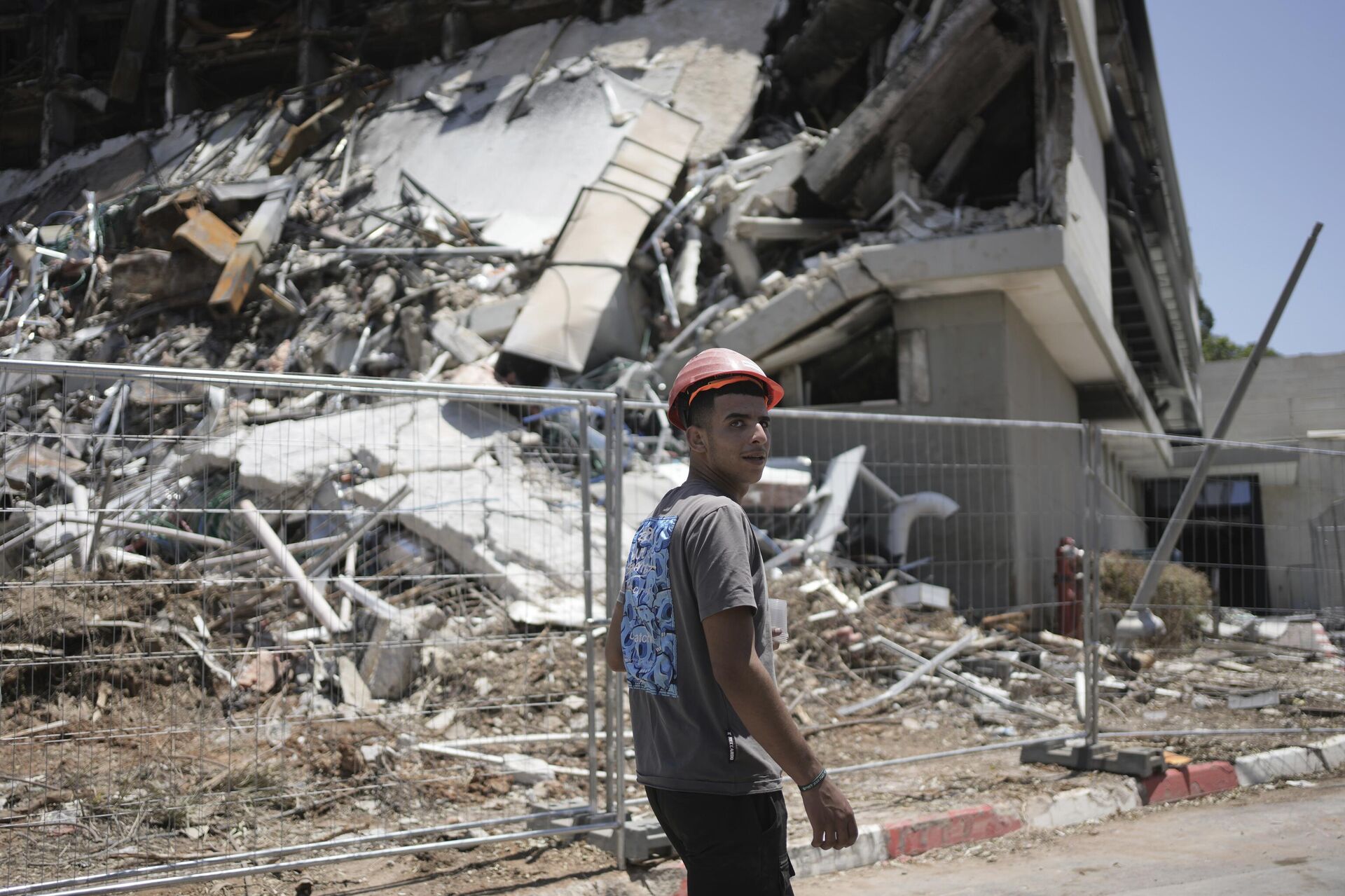 A worker walks past the life sciences building at the Weizmann Institute of Science, destroyed by an Iranian missile in Rehovot, Thursday, June 19, 2025.  - Sputnik International, 1920, 20.06.2025