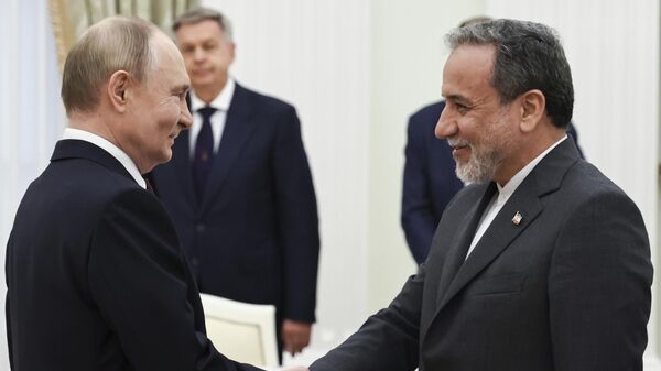 Russian President Vladimir Putin, left, greets Iranian Foreign Minister Abbas Araghchi prior to their talks at the Kremlin in Moscow, Russia, Monday, June 23, 2025. - Sputnik International
