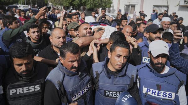 Mourners carry the body of Palestinian journalist Hassan Eslaiah, who was killed in an overnight Israeli strike on Nasser Hospital, with the Israeli military claiming he was targeted for being a Hamas militant involved in the October 7, 2023, attack on southern Israel that sparked the war, in Khan Younis, southern Gaza Strip, Tuesday, May 13.  - Sputnik International