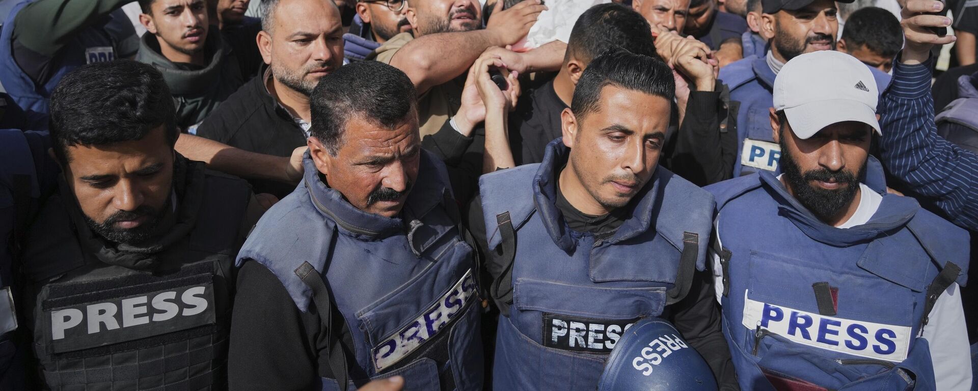 Mourners carry the body of Palestinian journalist Hassan Eslaiah, who was killed in an overnight Israeli strike on Nasser Hospital, with the Israeli military claiming he was targeted for being a Hamas militant involved in the October 7, 2023, attack on southern Israel that sparked the war, in Khan Younis, southern Gaza Strip, Tuesday, May 13.  - Sputnik International, 1920, 25.06.2025