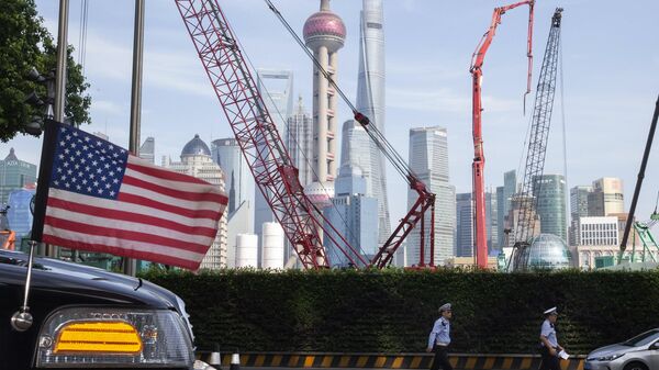 Chinese traffic police officers walk by a U.S. flag on an embassy car outside a hotel in Shanghai where officials from both sides met for talks aimed at ending a tariff war on July 30, 2019. - Sputnik International