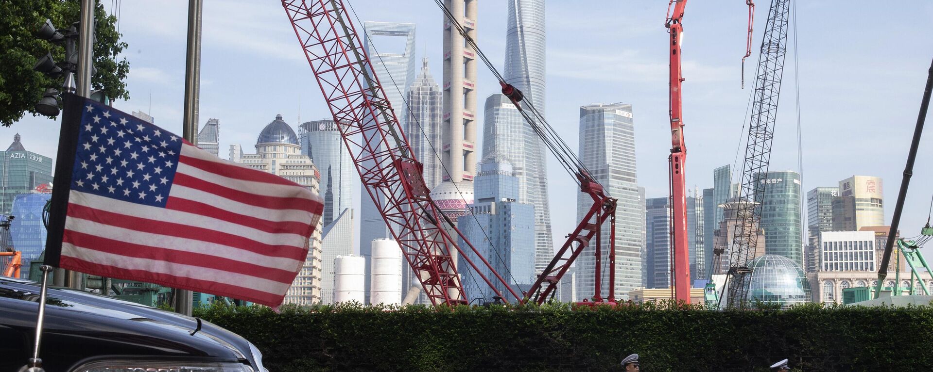 Chinese traffic police officers walk by a U.S. flag on an embassy car outside a hotel in Shanghai where officials from both sides met for talks aimed at ending a tariff war on July 30, 2019. - Sputnik International, 1920, 29.06.2025