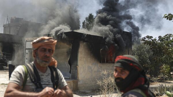 Bedouin fighters stand in front a burned shop at Mazraa village on the outskirts of Sweida city, during clashes between the Bedouin clans and Druze militias, southern Syria, Friday, July 18, 2025.  - Sputnik International