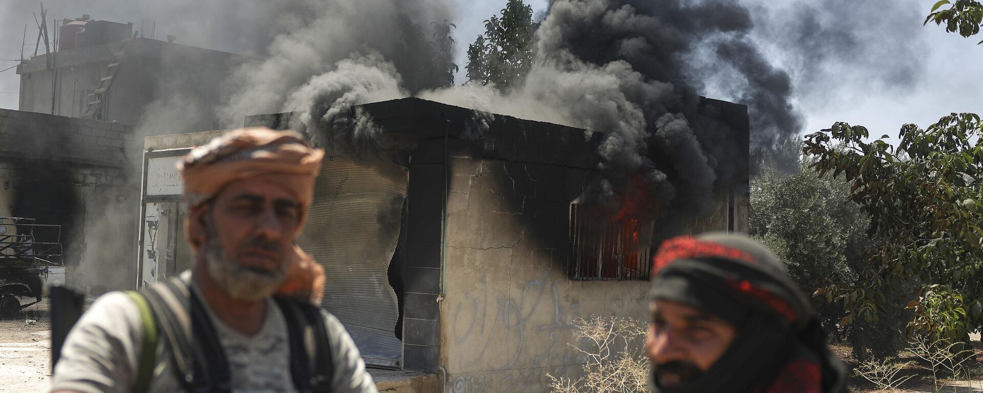 Bedouin fighters stand in front a burned shop at Mazraa village on the outskirts of Sweida city, during clashes between the Bedouin clans and Druze militias, southern Syria, Friday, July 18, 2025.  - Sputnik International, 1920, 20.07.2025