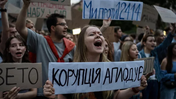 A woman chants while holding a banner that reads, “Corruption Applauds,” during a protest against a law targeting anti-corruption institutions in central Kiev, Ukraine, Tuesday, July 22, 2025 - Sputnik International