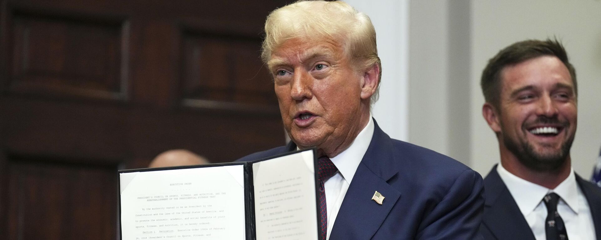 President Donald Trump holds up a signed executive order restarting the Presidential Fitness Test in public schools as professional golfer Bryson DeChambeau looks on, Thursday, July 31, 2025, in the Roosevelt Room of the White House in Washington - Sputnik International, 1920, 01.08.2025