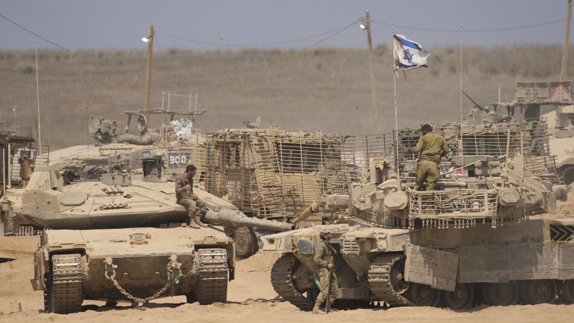 Israeli soldiers work on their tanks in a staging area on the border with Gaza Strip, in southern Israel, Tuesday, July 29, 2025 - Sputnik International, 1920, 29.10.2025