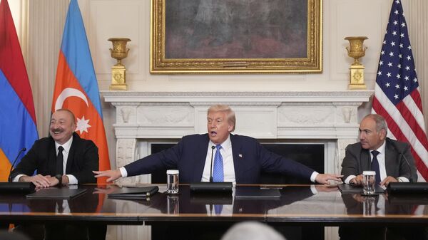 President Donald Trump, center, joined by Armenian Prime Minister Nikol Pashinyan, right, and Azerbaijan President Ilham Aliyev, speaks during a trilateral signing ceremony in the State Dining Room of the White House, Friday, Aug. 8, 2025, in Washington. (AP Photo/Mark Schiefelbein) - Sputnik International
