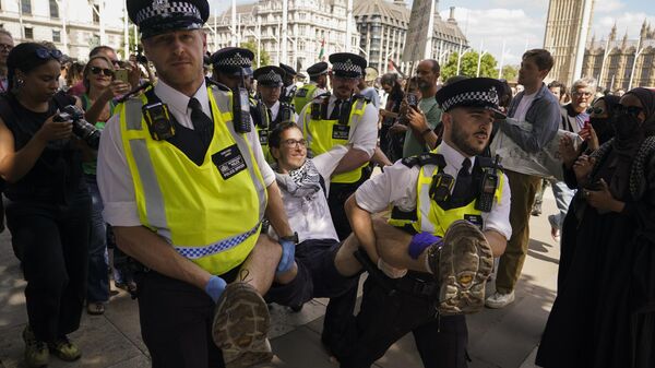Police officers arrest a demonstrator during a protest in support of the Palestinian people, in Parliament Square, in London, Saturday, Aug. 9, 2025 - Sputnik International