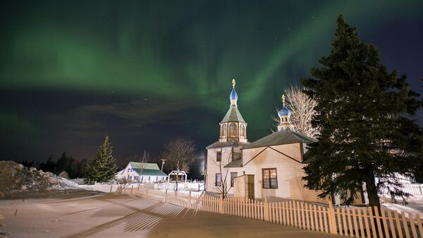 In this March 17, 2013, file photo, the aurora borealis, or northern lights, fill the night sky above the Holy Assumption of the Virgin Mary Russian Orthodox church in Kenai, Alaska - Sputnik International