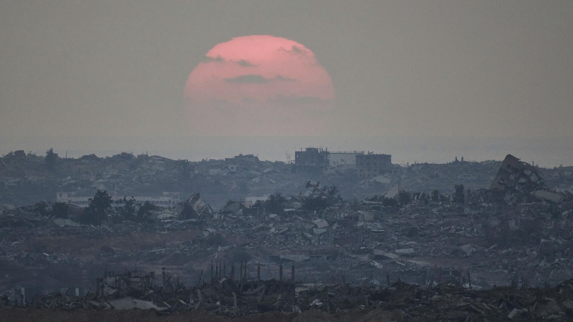 The sun sets behind buildings destroyed during Israeli ground and air operations in the northern Gaza Strip, as seen from southern Israel, Aug. 8, 2025 - Sputnik International, 1920, 07.10.2025