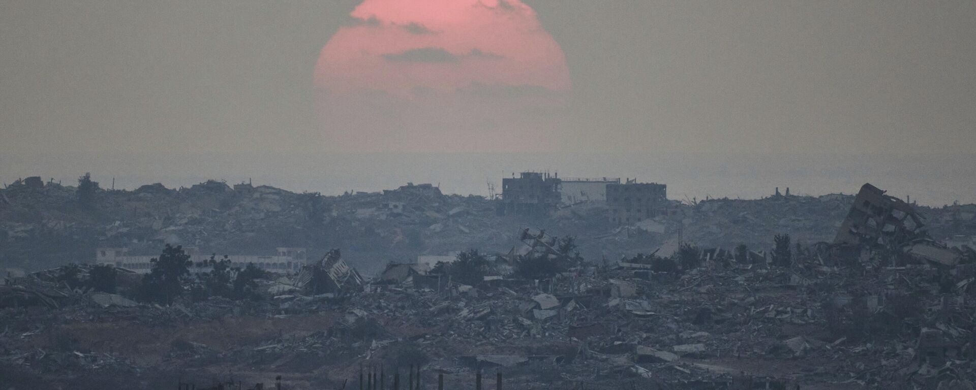 The sun sets behind buildings destroyed during Israeli ground and air operations in the northern Gaza Strip, as seen from southern Israel, Aug. 8, 2025 - Sputnik International, 1920, 16.09.2025