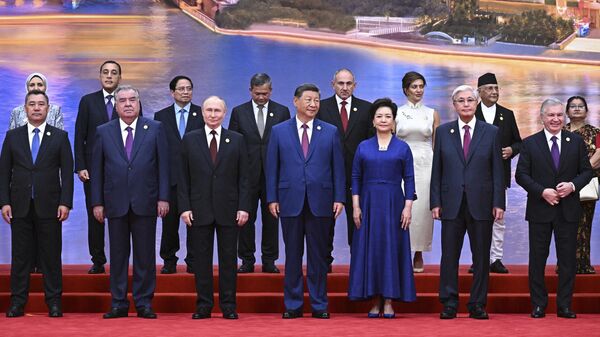 Russian President Vladimir Putin, center left, Chinese President Xi Jinping, center, and his wife Peng Liyuan, center right, pose for a photo with other leaders during a ceremony to welcome heads of state at the Shanghai Cooperation Organization (SCO) summit in Tianjin, China, on Sunday, Aug. 31, 2025 - Sputnik International