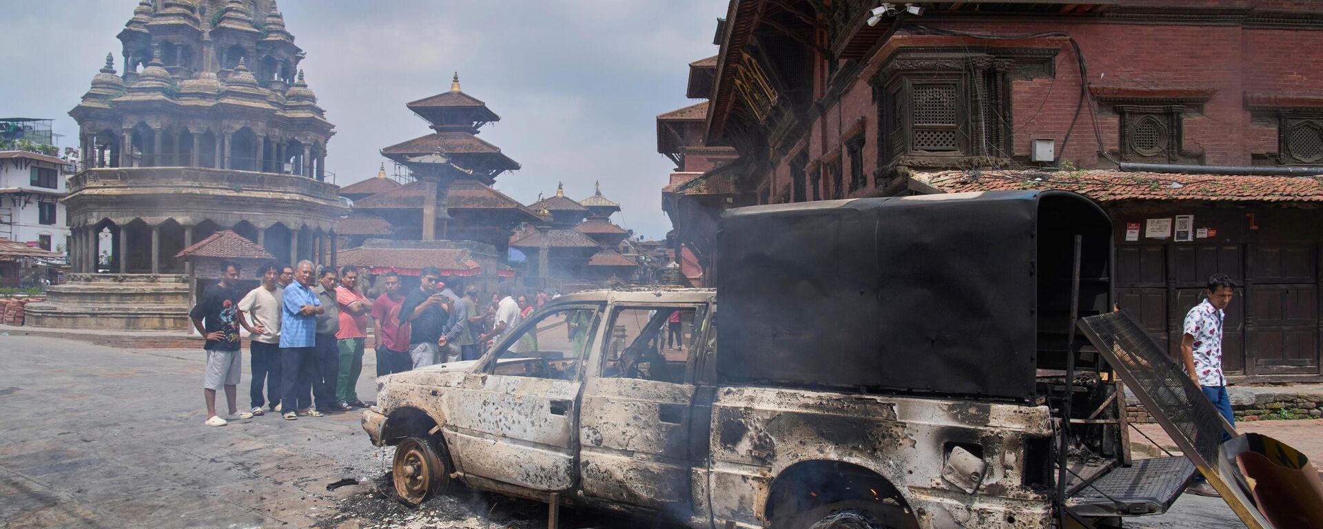 People look at a burnt police vehicle during protests against social media ban and corruption in Kathmandu, Nepal, Tuesday, Sept. 9, 2025.  People look at a burnt police vehicle during protests against social media ban and corruption in Kathmandu, Nepal, Tuesday, Sept. 9, 2025.  - Sputnik International, 1920, 10.09.2025