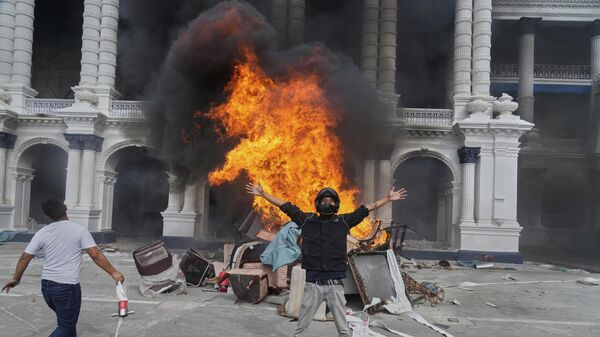Protesters celebrate at the Singha Durbar, the seat of Nepal's government's various ministries and offices, after it was set on fire during a protest against social media ban and corruption in Kathmandu, Nepal, Tuesday, Sept. 9, 2025.  - Sputnik International