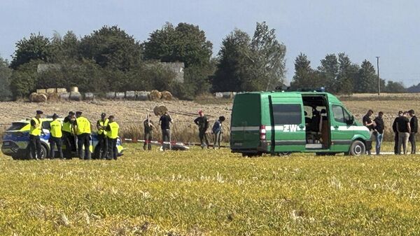 Police and Military Police secure parts of a damaged UAV shot down by Polish authorities lie at a site in Wohyn, Poland, Wednesday, Sept. 10, 2025. (AP Photo/Rafal Niedzielski) - Sputnik International