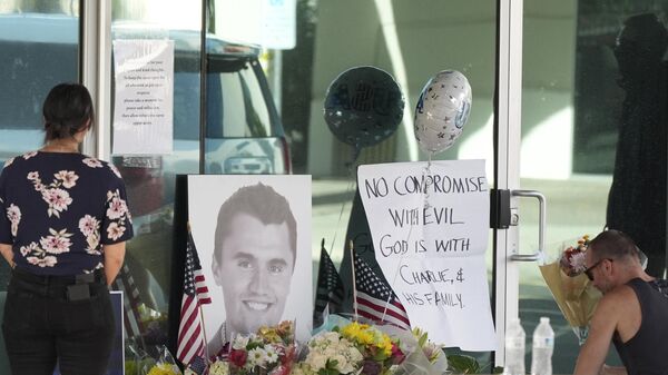 Well-wishers pay their respects at a makeshift memorial at the national headquarters of Turning Point USA shown after the shooting death of Charlie Kirk, the co-founder and CEO of the organization, during a Utah college event Wednesday, Sept. 10, 2025, in Phoenix. (AP Photo/Ross D. Franklin) - Sputnik International