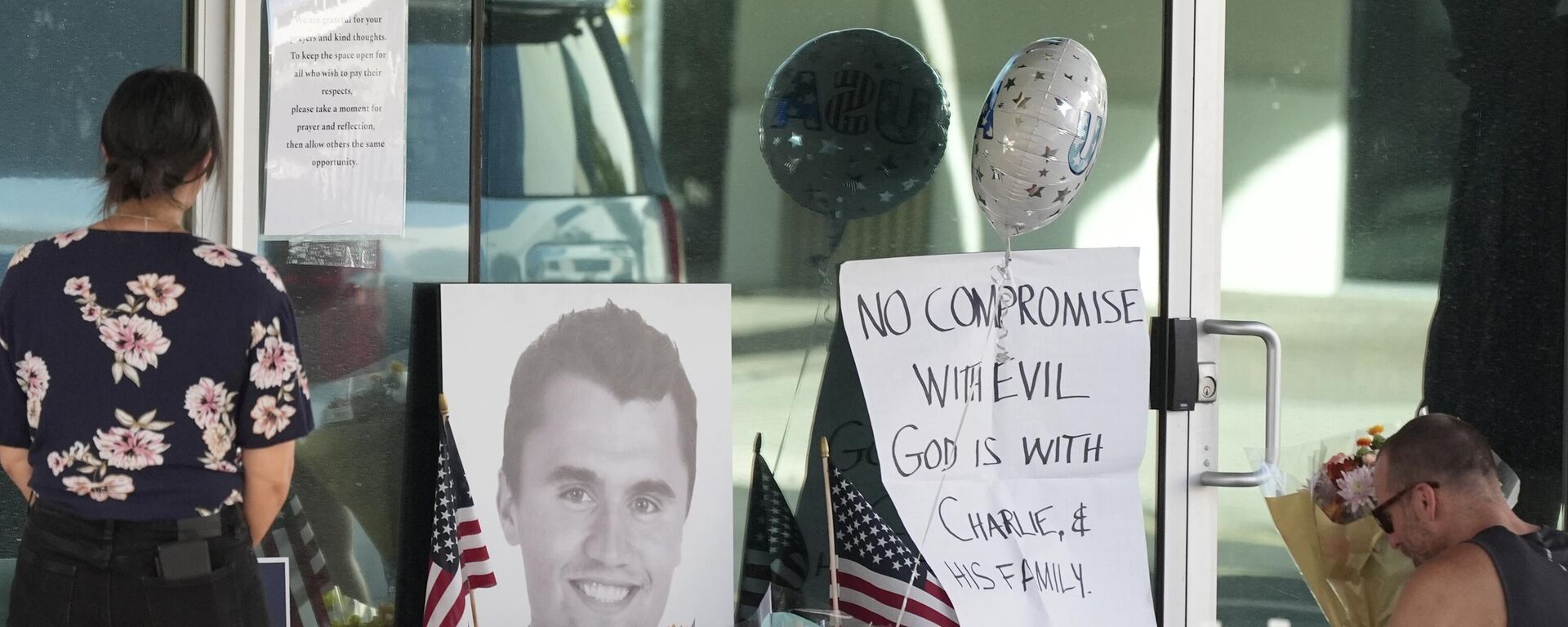 Well-wishers pay their respects at a makeshift memorial at the national headquarters of Turning Point USA shown after the shooting death of Charlie Kirk, the co-founder and CEO of the organization, during a Utah college event Wednesday, Sept. 10, 2025, in Phoenix. (AP Photo/Ross D. Franklin) - Sputnik International, 1920, 11.09.2025