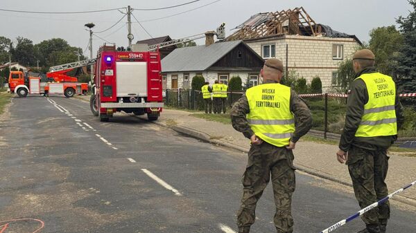 Firefighters and territorial defence officers stand close to the destroyed roof of a house after drones violated Polish airspace in Wyryki near Lublin, Poland, Thursday, Sept. 11, 2025.  - Sputnik International