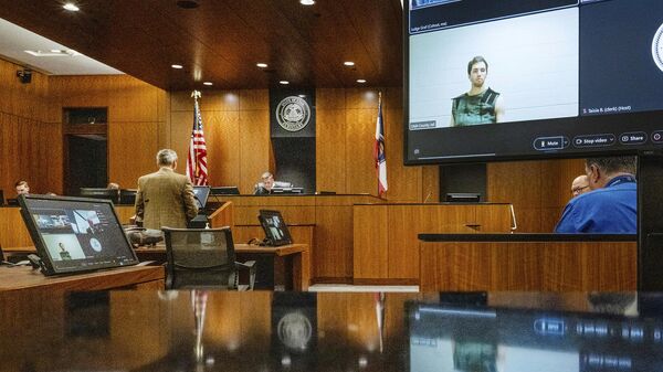 Defense attorney Greg Skordas, left, speaks before Judge Tony Graf, background, in Provo, Utah, as Tyler Robinson, in monitor at right, accused of fatally shooting Charlie Kirk, attends the court hearing virtually from prison on Tuesday, Sept. 16, 2025 - Sputnik International
